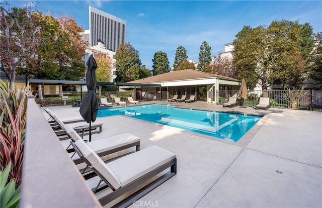 community pool featuring fence and a patio