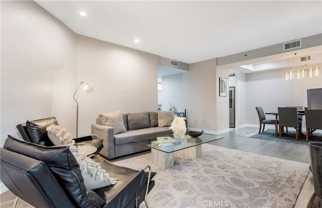 living area featuring visible vents, baseboards, and wood finished floors