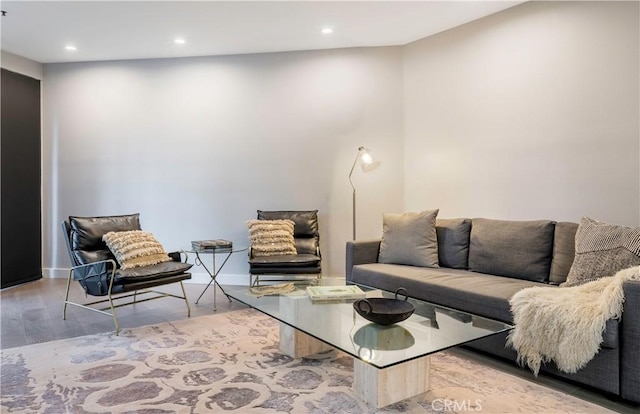 living room with baseboards, wood finished floors, and recessed lighting