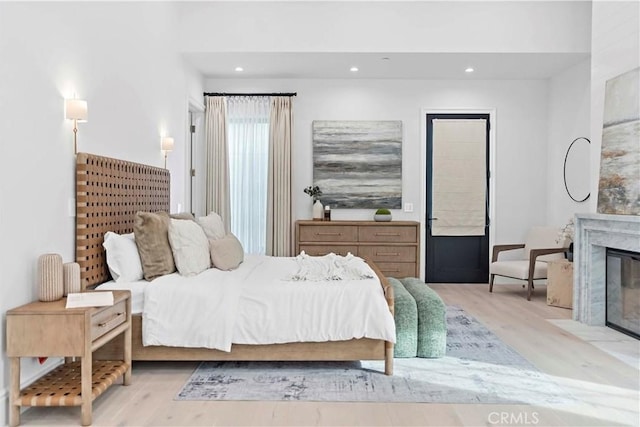 bedroom featuring a fireplace, recessed lighting, and light wood-style floors