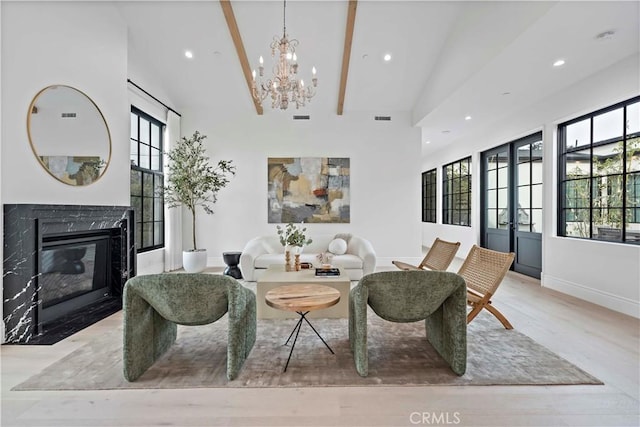 living room featuring visible vents, a notable chandelier, a healthy amount of sunlight, and a fireplace