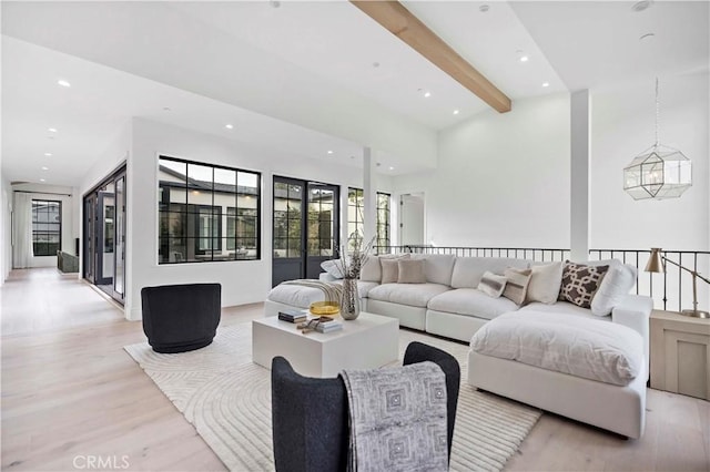 living area featuring beamed ceiling, recessed lighting, light wood-style floors, and baseboards