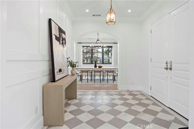 interior space with ornamental molding and an inviting chandelier