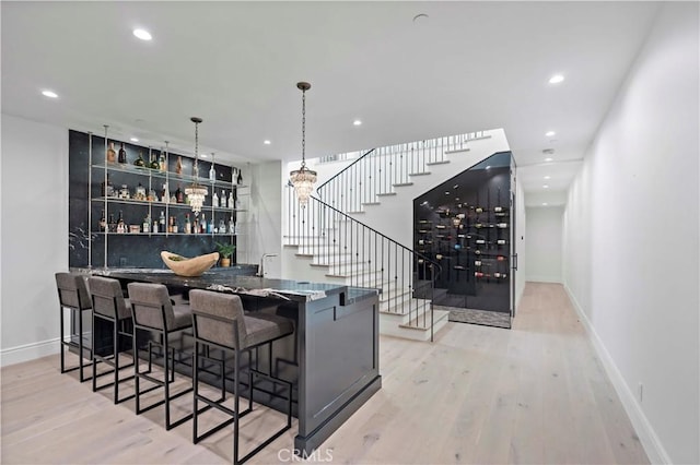 bar with baseboards, stairway, recessed lighting, wet bar, and wood finished floors