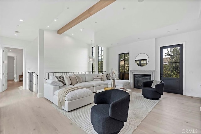 living room featuring vaulted ceiling with beams and light hardwood / wood-style floors