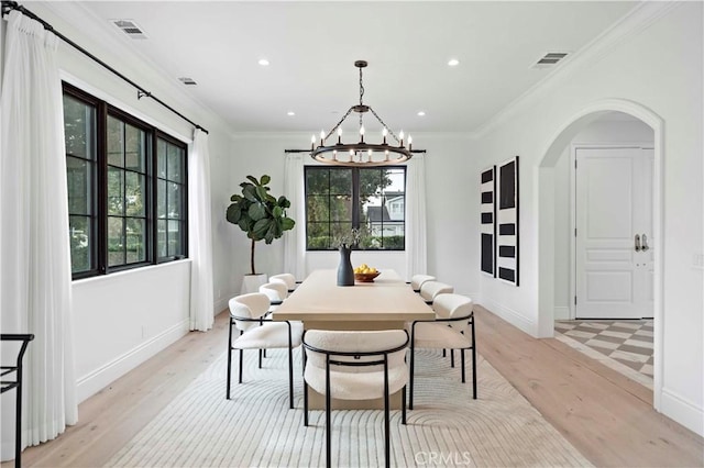 dining space with visible vents, arched walkways, a notable chandelier, and ornamental molding