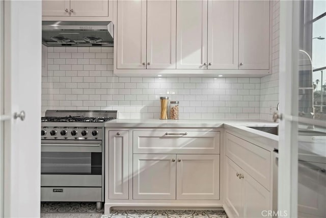 kitchen with high end stainless steel range oven, tasteful backsplash, exhaust hood, and white cabinets