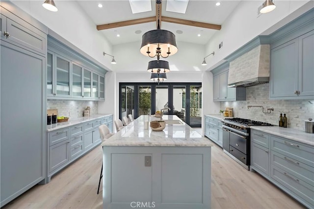 kitchen featuring hanging light fixtures, a skylight, sink, and beamed ceiling