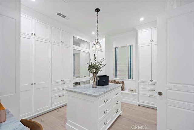 walk in closet featuring visible vents, light wood-style flooring, and an inviting chandelier