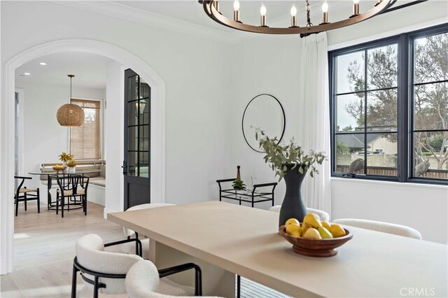 dining space featuring ornamental molding and light hardwood / wood-style floors