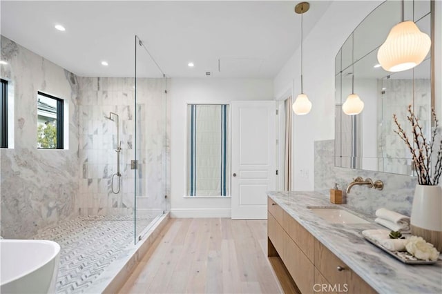 bathroom with vanity, wood finished floors, a freestanding tub, recessed lighting, and a stall shower