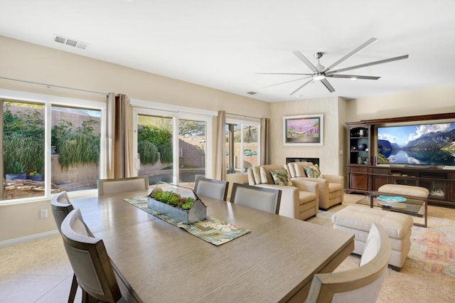 tiled dining room featuring ceiling fan and a healthy amount of sunlight