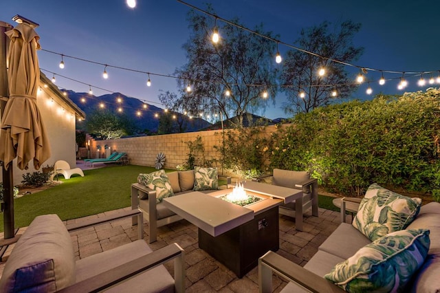 patio at twilight featuring a lawn and an outdoor living space with a fire pit