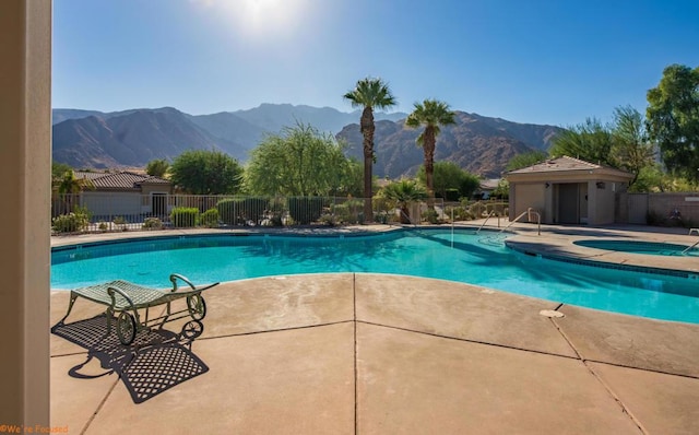 view of pool with a mountain view, a patio area, and an in ground hot tub