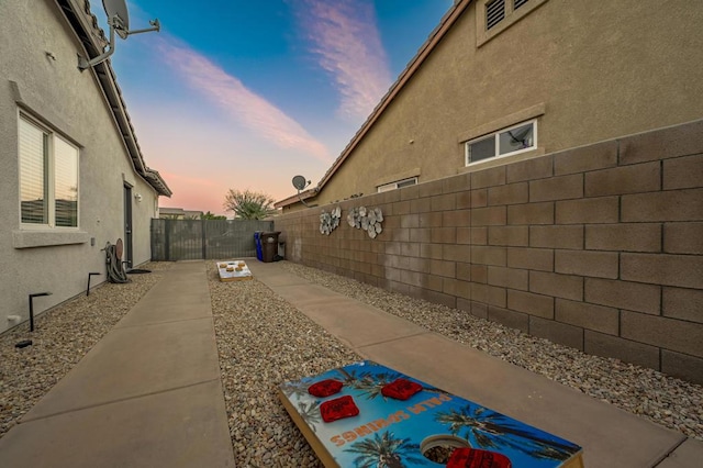 property exterior at dusk featuring a patio area