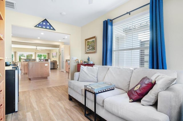 living room with light hardwood / wood-style floors and ceiling fan