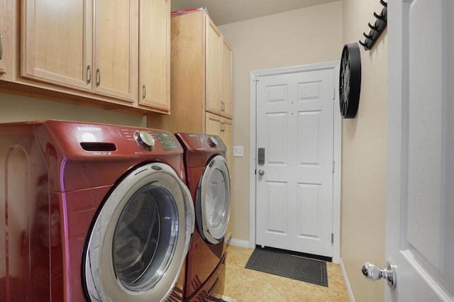 laundry room featuring light tile patterned floors, cabinets, and washer and clothes dryer