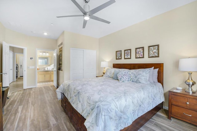 bedroom featuring ceiling fan, light hardwood / wood-style floors, connected bathroom, and a closet