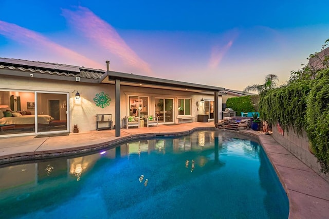 pool at dusk with a patio