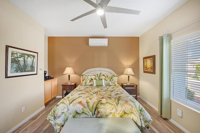 bedroom with ceiling fan, hardwood / wood-style flooring, and a wall unit AC