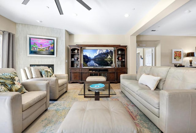 living room featuring ceiling fan and a fireplace