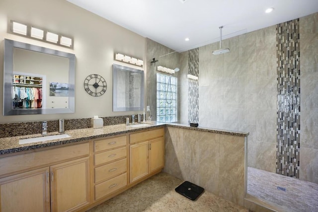 bathroom featuring tiled shower and vanity