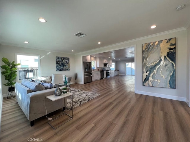 living room featuring wood-type flooring and crown molding