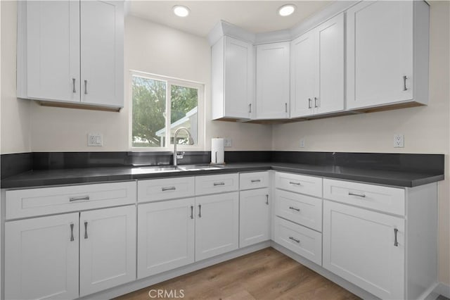 kitchen featuring white cabinetry, light hardwood / wood-style flooring, and sink