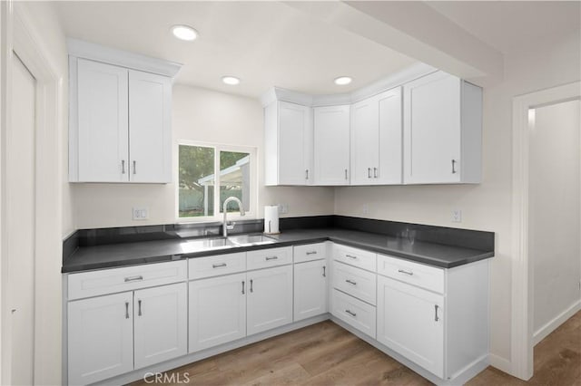 kitchen featuring white cabinets, sink, and light hardwood / wood-style floors