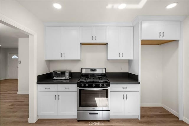 kitchen featuring gas range, light hardwood / wood-style floors, and white cabinets