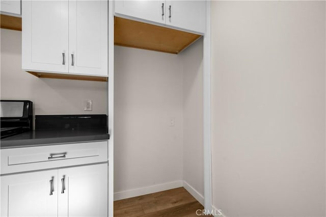 kitchen featuring dark wood-type flooring and white cabinetry