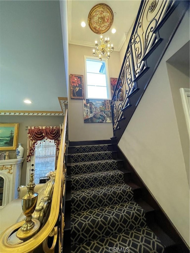 stairway featuring ornamental molding and a chandelier