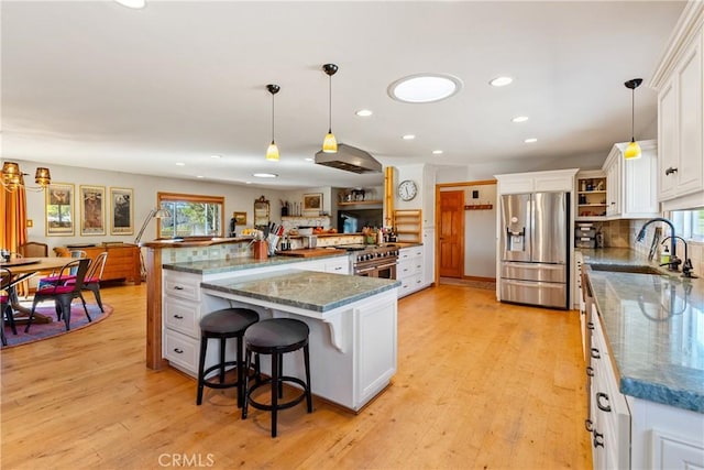 kitchen with decorative light fixtures, white cabinetry, and appliances with stainless steel finishes