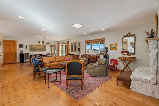 living room with light wood-type flooring and an inviting chandelier