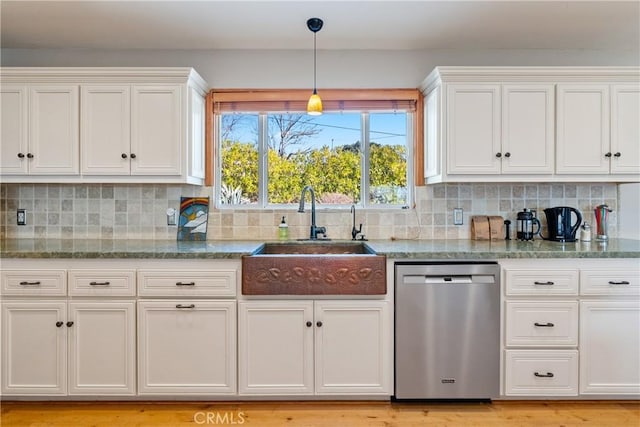 kitchen featuring dark stone countertops, stainless steel dishwasher, decorative backsplash, sink, and white cabinetry