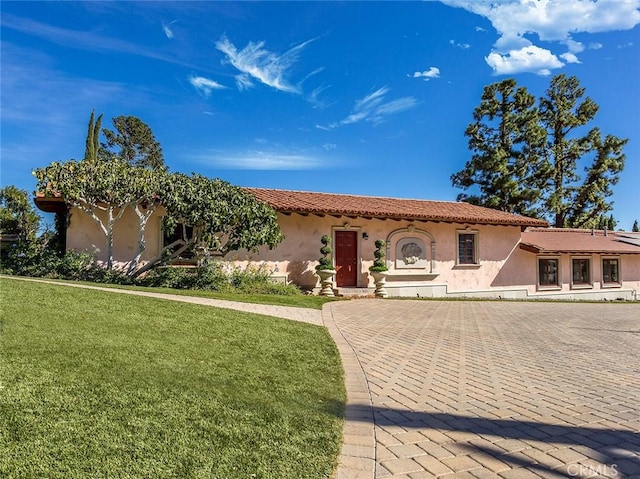 mediterranean / spanish house featuring a front lawn