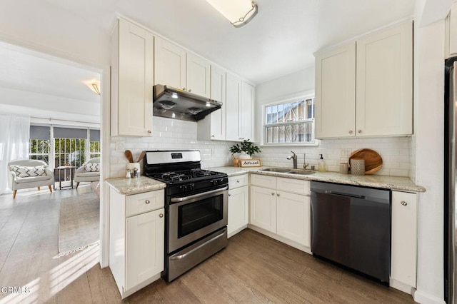 kitchen with white cabinets, decorative backsplash, sink, and stainless steel appliances