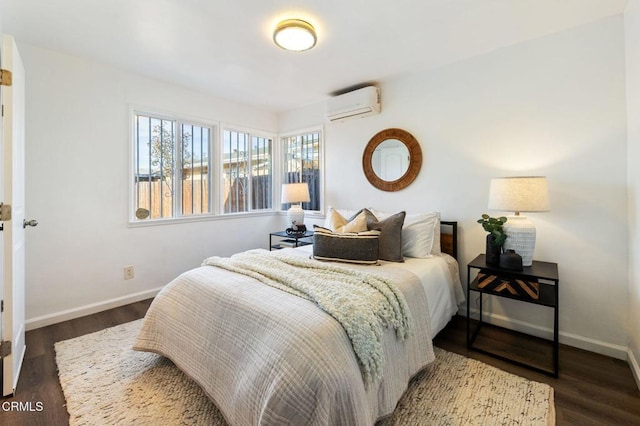 bedroom with a wall unit AC and dark hardwood / wood-style flooring