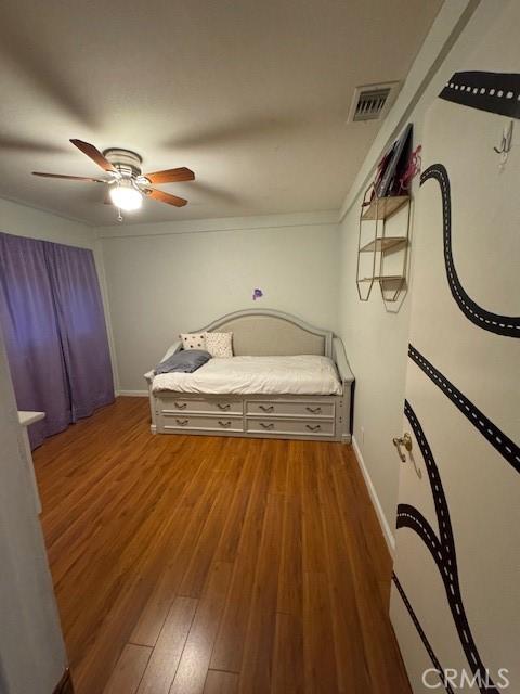 unfurnished bedroom with ceiling fan, dark hardwood / wood-style floors, and crown molding