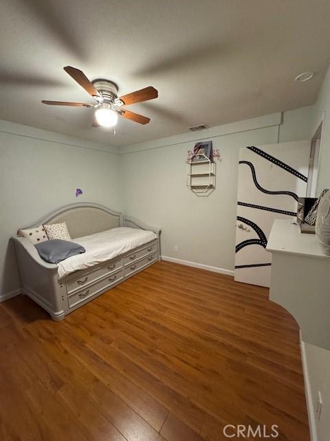 unfurnished bedroom with ceiling fan and dark wood-type flooring