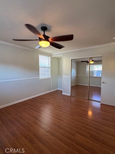 unfurnished bedroom featuring ceiling fan, a closet, dark hardwood / wood-style floors, and ornamental molding