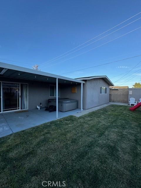 back of property featuring a patio area and a yard