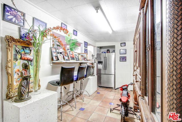 kitchen featuring light tile patterned floors and stainless steel fridge with ice dispenser