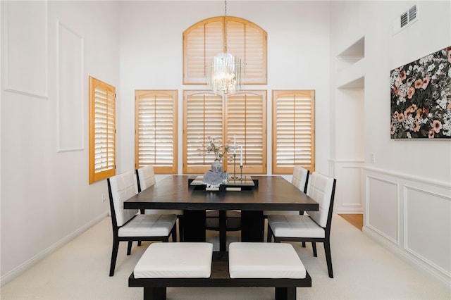 carpeted dining space featuring a notable chandelier