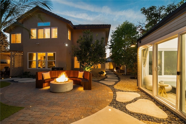 patio terrace at dusk featuring an outdoor fire pit