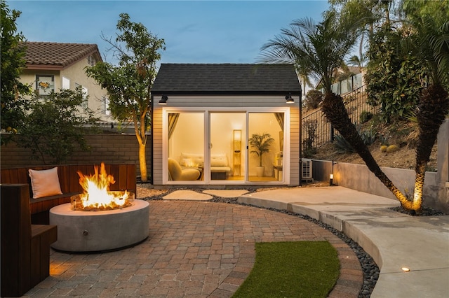 outdoor structure at dusk featuring an outdoor fire pit