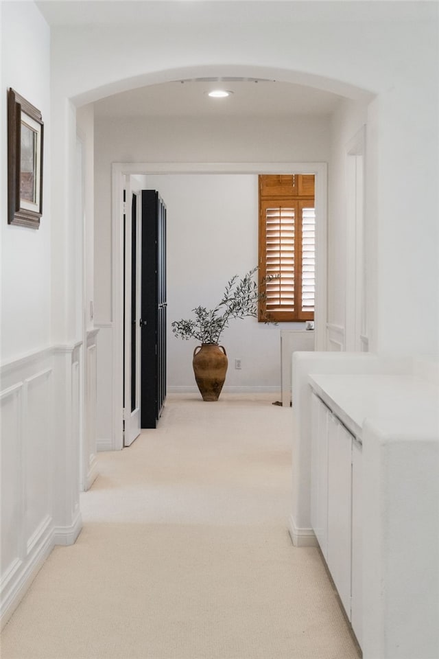 hallway featuring light colored carpet