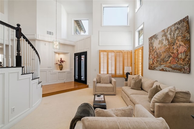 carpeted living room with a towering ceiling