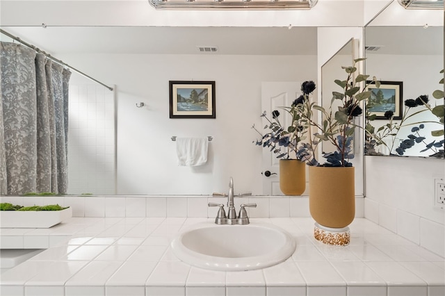 bathroom featuring walk in shower and vanity