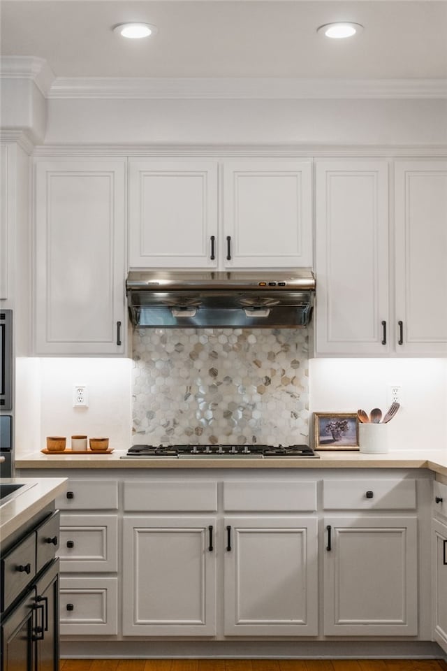 kitchen with white cabinetry, decorative backsplash, stainless steel gas cooktop, oven, and crown molding